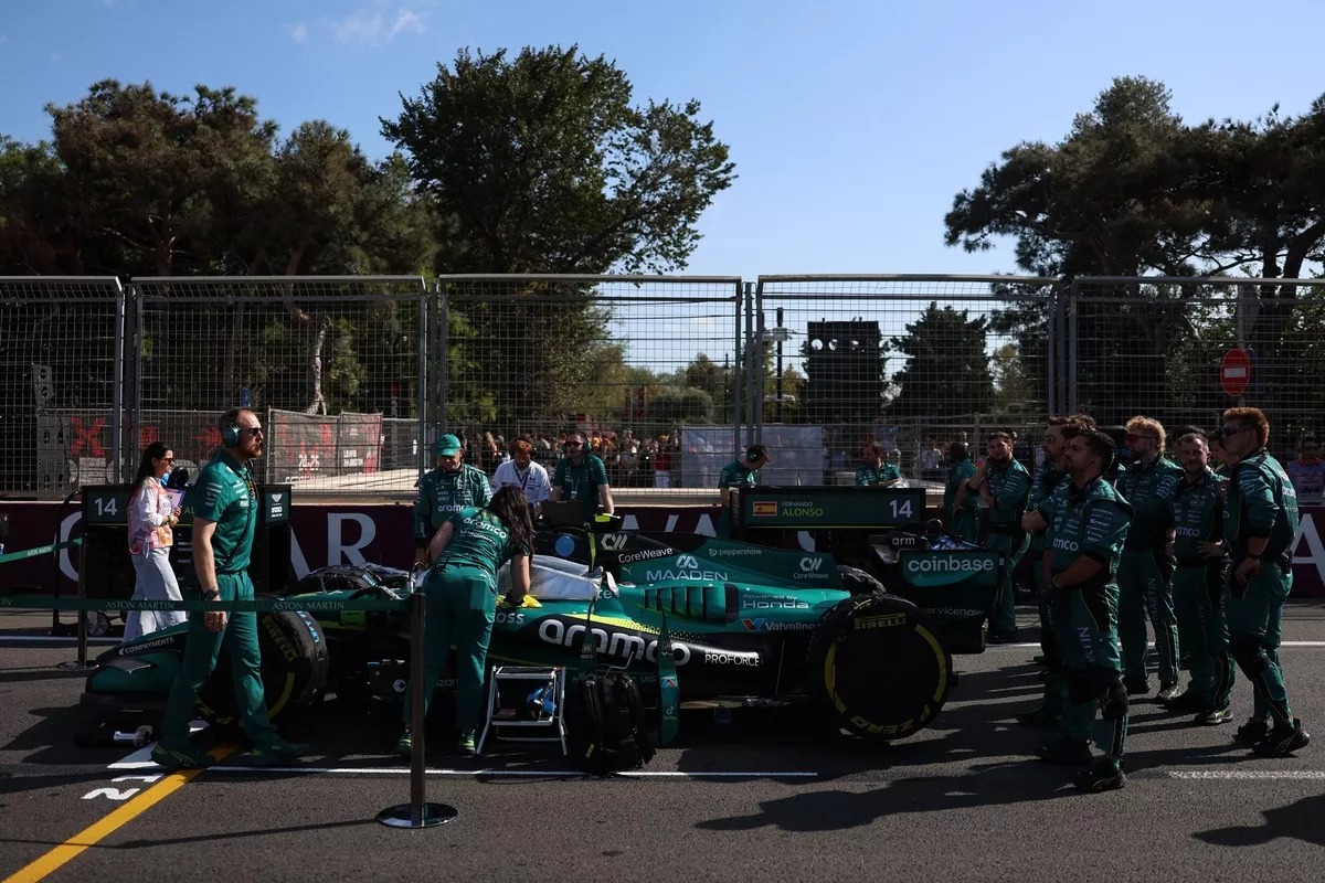 Fernando Alonso observa su Aston Martin tras el abandono en la vuelta 21, por un problema anómalo en la unidad de potencia Honda